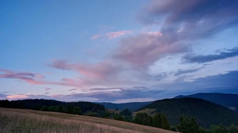 Colorful clouds at sunset over the hilly and forest landscape Stock Footage 161457858