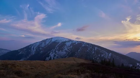 Colorful clouds at sunset, in a spring mountain landscape, melting snow. Stock Footage 167838883