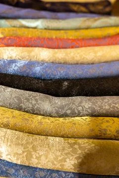 Colorful collection of patterned textiles displayed in a market setting Stock Photos