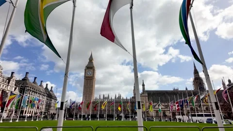 Colorful Commonwealth flags flutter in Parliament Square Garden with Big Ben Vídeo Stock 332254666