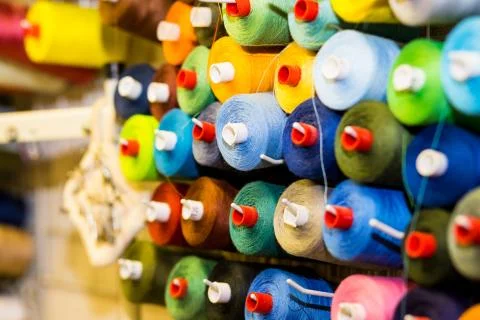 Colorful cones and spools of thread at an atelier.Tailoring, garment industry Stock Photos