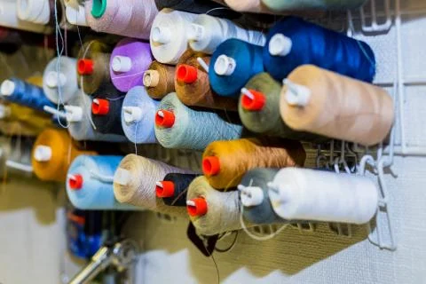 Colorful cones and spools of thread at an atelier.Tailoring, garment industry Stock Photos