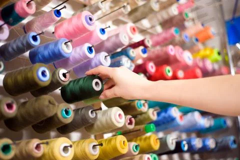 Colorful cones and spools of thread at an atelier.Tailoring, garment industry Stock Photos