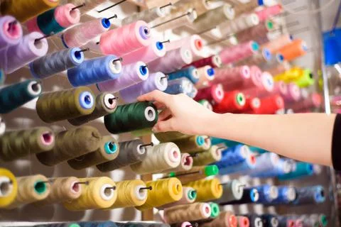 Colorful cones and spools of thread at an atelier.Tailoring, garment industry Stock Photos