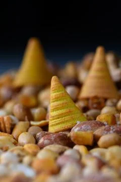 Colorful cones nestled among an array of earthy nuts create a whimsical lan.. 写真素材