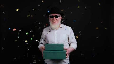 Colorful confetti falling down in front of an albino man with gift box in hands. Stock Footage 142215748