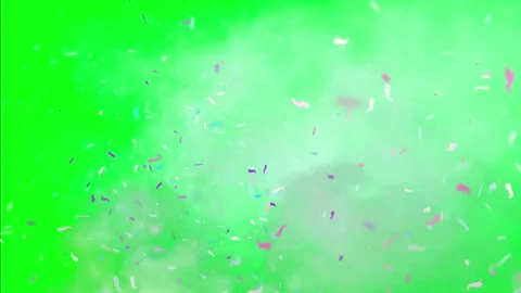 Colorful confetti falling on green background with smoke Видео 338222014