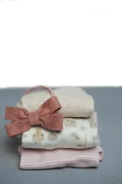 Colorful cotton folded clothes stack on white table empty space background,baby Stock Photos
