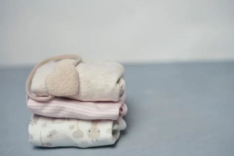 Colorful cotton folded clothes stack on white table empty space background,baby Stock Photos