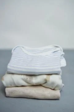 Colorful cotton folded clothes stack on white table empty space background,baby Stock Photos