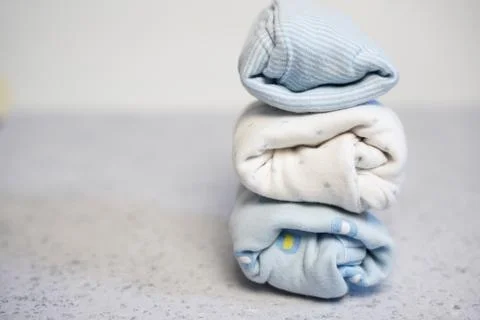 Colorful cotton folded clothes stack on white table empty space background,baby Stock Photos