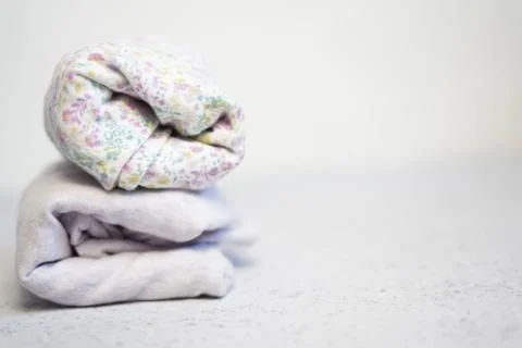 Colorful cotton folded clothes stack on white table empty space background,baby Stock Photos