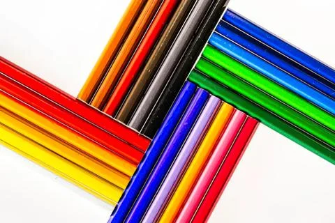 Colorful crayons arranged in a fun pattern on white background Stock Photos