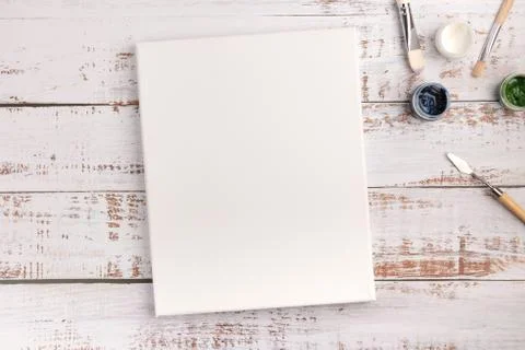 Colorful creative table with blank canvas for sketches and paints, paintbrush Stock-Fotos