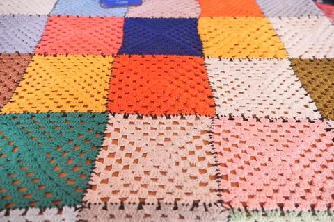Colorful crochet patchwork blanket on a table Photos