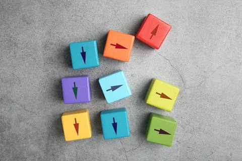 Colorful cubes with arrows pointing in different directions on grey backgro.. Stock Photos