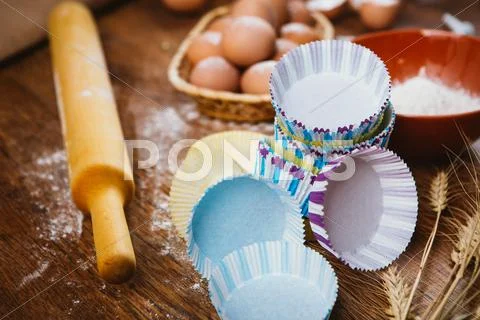 Colorful Cupcake Wrappers With Baking Pan On Wooden Background