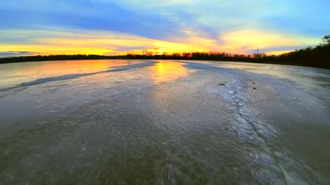 Colorful dawn sky reflected in the thin ice of a new day Stock Footage 295304837