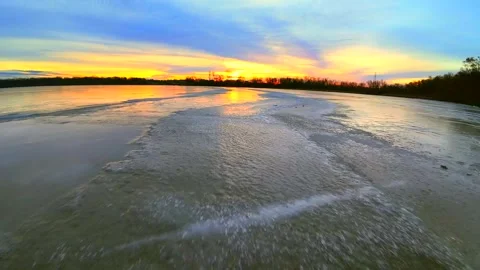 Colorful dawn sky reflected in the thin ice of a new day Stock Footage 295314498