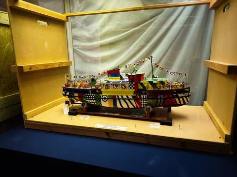 Colorful dazzle patterned model boat on display in a museum showcase in Liv.. Stock Photos