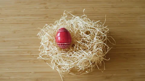 Colorful decorated Easter eggs appearing in a hay nest on wooden background. Stock Footage 149064850