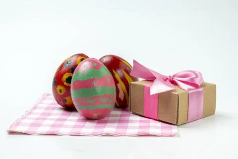 Colorful decorated easter eggs with a gift box on a checkered square cloth .. Stock Photos