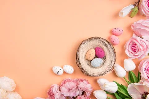 Colorful decorations with Easter egg nest with spring flowers on orange Stock Photos