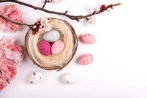 Colorful decorations with Easter egg nest with ink flowers on white background Stock Photos
