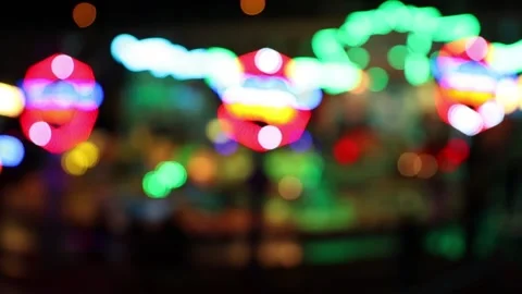 Colorful defocused changing lights of carousel ride at night Stock Footage 154649191