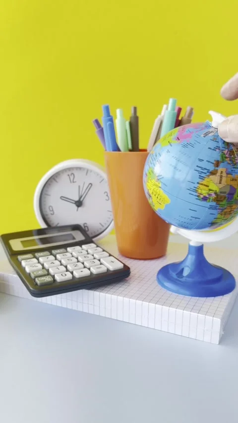 Colorful Desk Setup with Globe and Calculator A workspace scene featuring a.. Stock Footage 309397105
