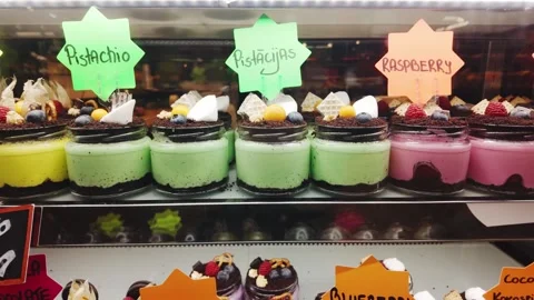 Colorful Dessert Cups Displayed Inside Bright Pastry Showcase, Sweet Toppings Stock Footage 336339396