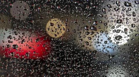 Colorful diffuse unsharp lights behind glass window with rain drops Stock Photos