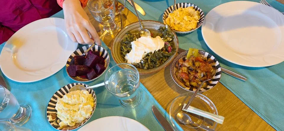 Colorful dining table setup with various dishes and empty plates ready for Foto stock