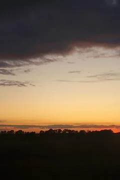 Colorful dramatic sky with cloud at sunset over fields and forest near Kyiv 写真素材