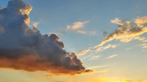 A colorful, dramatic sky featuring purple and gold clouds at sunset Stock Photos