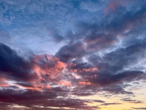 Colorful dramatic sky with violet blue rose purple red layered clouds at sunset Stock Photos
