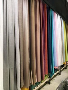 Colorful drapes in a store, showcasing multiple fabric options for windows Stock Photos