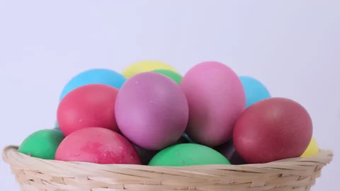 Colorful Easter chicken eggs rotating in basket on light background Video stock 171345487