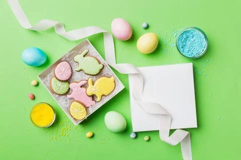 Colorful easter cookies in basket with Multi colors Easter eggs on colored .. Stock Photos