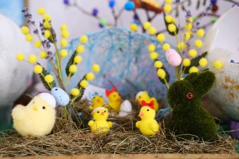 Colorful Easter craft scene featuring fluffy yellow chicks, a green bunny, and Stock Photos