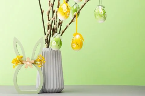 Colorful Easter decorations with eggs on branches in a vase and bunny figur.. Stock Photos