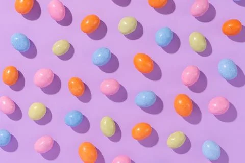 Colorful easter dragee on a violet background Stock Photos
