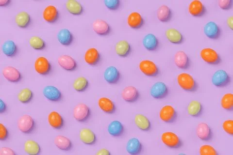 Colorful easter dragee on a violet background Stock Photos