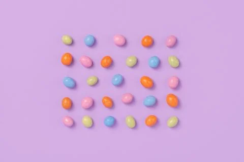 Colorful easter dragee on a violet background Stock Photos