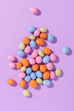 Colorful easter dragee on a violet background Stock Photos