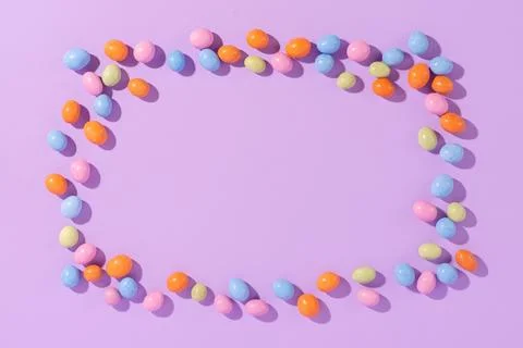 Colorful easter dragee on a violet background Stock Photos