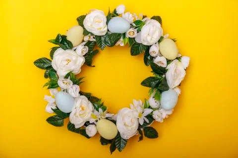 A colorful Easter egg wreath isolated over yellow background. Easter holiday  Stock Photos