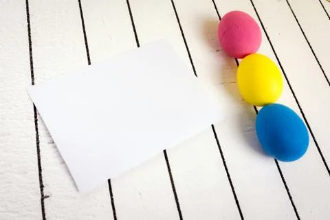 Colorful Easter eggs and blank white sheet of wood background. Eco-friendly Stock Photos