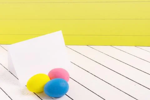Colorful Easter eggs and blank white sheet of wood background Stock Photos