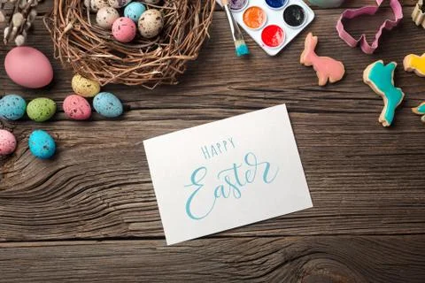 Colorful easter eggs and brushes on wooden table. Top view with copy space Stock Photos